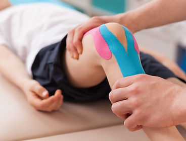 Physiotherapist providing therapy to a childs knee.