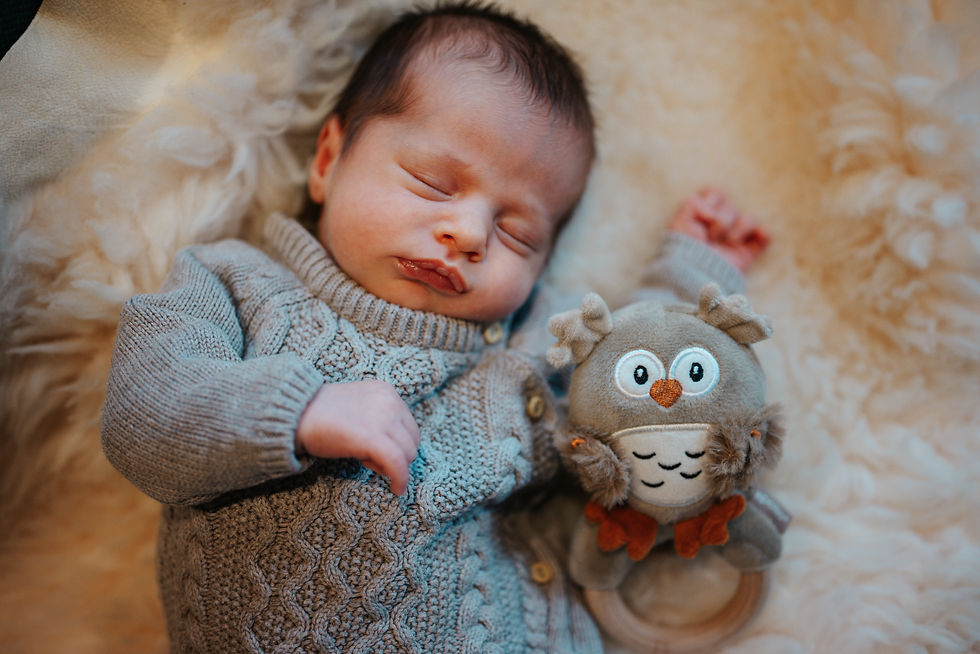 Ein schlafendes, neugeborenes Baby auf einem Lammfeld.