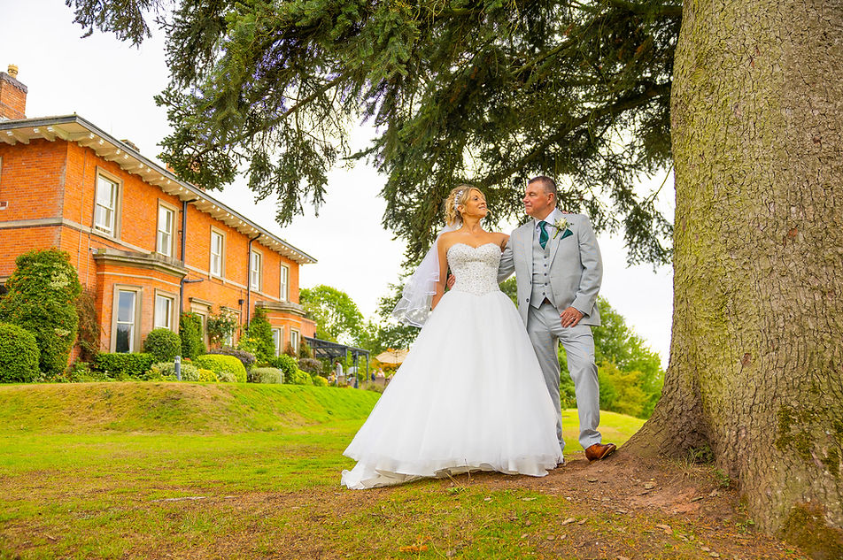 Posed couple standing under picturesque tree and The Upper House