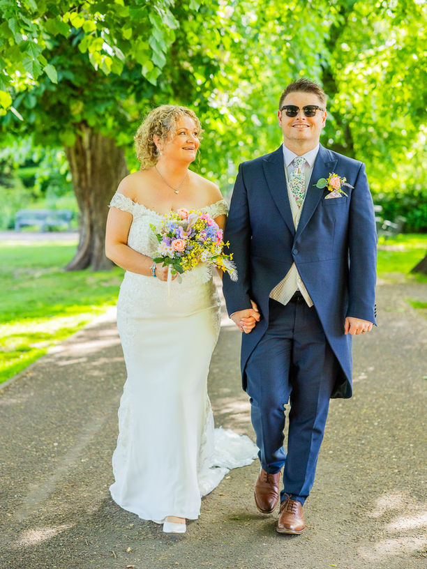 Bride looks adoringly at groom in Lichfield Park under the trees