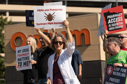protestors holding signs in front of OptumRx headquarters in Eden Prairie, MN