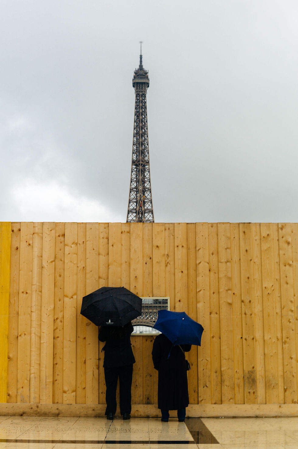 People looking through a construction fence