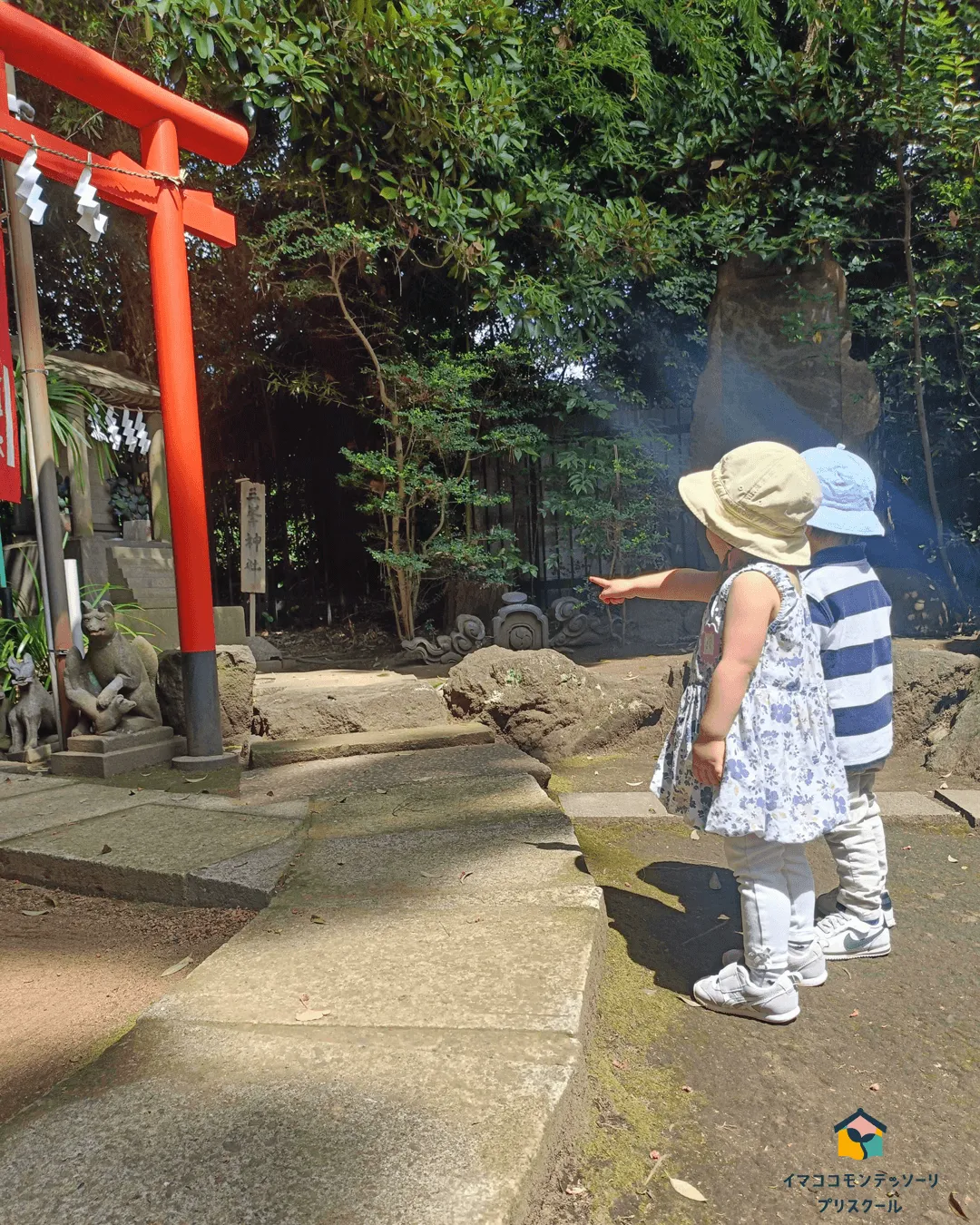 赤い鳥居の下に何かを発見した子どもたち