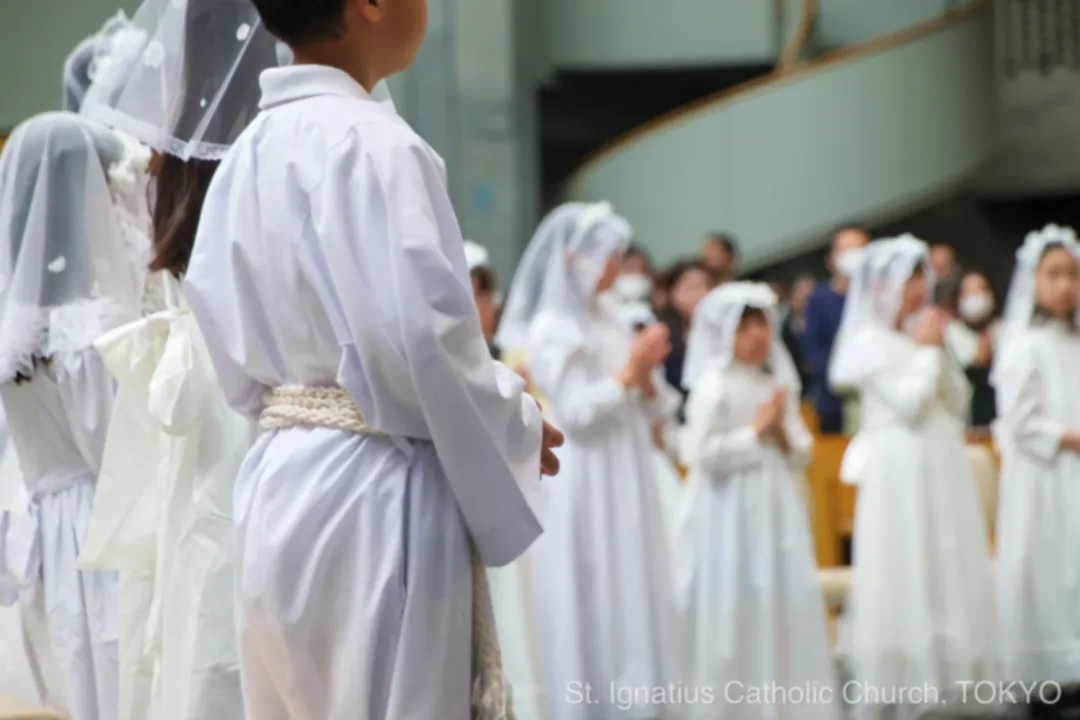 初聖体を受けるため祭壇を囲む子どもたち