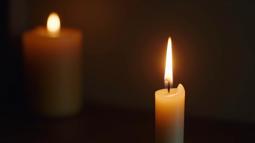 Close-up view of a calm candle burning in a dimly lit room