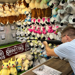a man trying to win a teddy bear by а shooting game