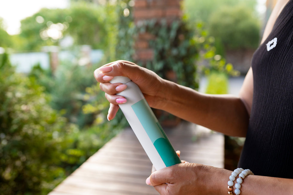 Donna che tiene in mano uno spray repellente su una terrazza immersa nel verde