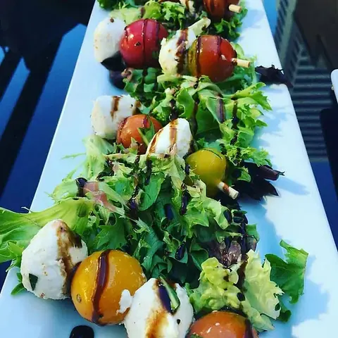 Fresh salad dish at The Woolworth Dallas, TX – mixed greens with cherry tomatoes, avocado, and a light vinaigrette, offering a healthy and delicious option for diners.