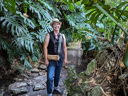 Christy standing in a jungle-like setting, smiling.