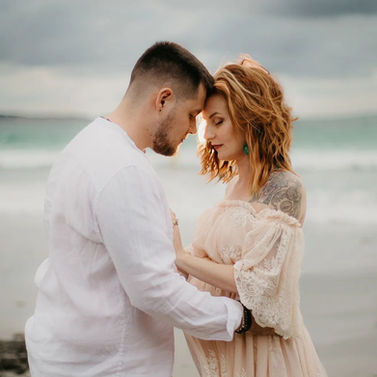 Couple à la plage, femme rousse avec coiffure ondulée.