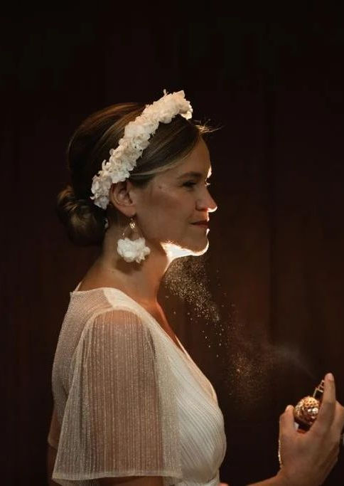 Mariée de profil se vaporisant du parfum