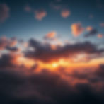 A breathtaking sunset paints the sky with vibrant hues of orange and pink as the sun dips below a blanket of fluffy clouds, creating a serene and enchanting atmosphere.