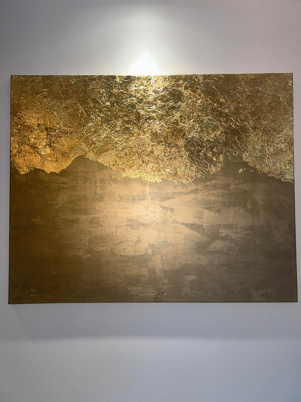 Cette toile, baignée de dorures, invite à se perdre dans l’immensité d’un désert imaginaire. Sous son apparente simplicité, elle recèle une richesse insoupçonnée : le jeu subtil de la lumière et de la matière évoque des dunes infinies, des vagues figées dans le temps ou des montagnes baignées d’éclat.
Le désert, symbole d’immensité et de mystère, est ici à la fois vide et chargé d’histoires. Chaque feuille d’or, chaque nuance, semble murmurer l’équilibre fragile entre la chaleur et le froid, l’immobilité et le mouvement. Cette toile, comme le désert, reflète ce paradoxe : un néant d’une richesse infinie, où tout est question de regard et de perception.
100 x 80 peinture d’or - feuilles d’or