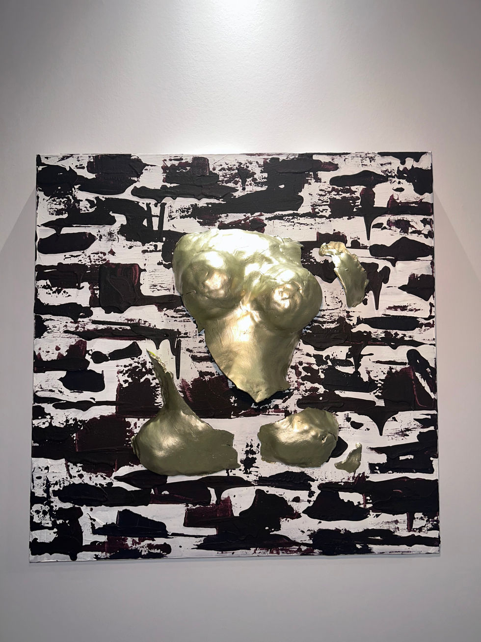 Dans un monde où le temps façonne les êtres comme il sculpte la roche, “Pierre” raconte l’histoire d’un corps à la fois figé et vibrant, brisé et pourtant indestructible.
Accroché à un mur texturé, entre l’ombre et la lumière, ce torse morcelé semble émerger d’une matière brute, comme s’il avait toujours été là, empreint des marques du passé. Son enveloppe dorée, lisse et froide, évoque une armure, une façade imposante qui cache pourtant une richesse intérieure insoupçonnée. Car sous cette surface métallique, la couleur palpite. Comme une veine souterraine, un feu secret, un souffle de vie enfermé dans la pierre.
Mais “Pierre” n’est pas seulement une matière inerte. Il est mémoire, il est résistance. Il est ce corps qui refuse de disparaître, qui, même brisé, continue d’exister. Il incarne la dualité entre l’homme et le temps, entre l’artifice et l’organique, entre ce que l’on montre et ce que l’on est réellement.
60 x 60 ACRYLIQUE - ARGILE - PEINTURE D’OR
