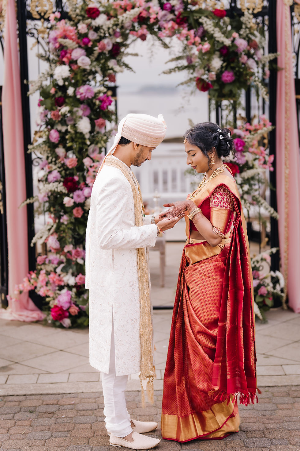 Muthu wore a saree in traditional wedding day red for the ceremony part of the day and Gaurav chose a cream sherwani coat. For the evening reception, Muthu donned a cream lehenga choli with beautiful floral detail and Gaurav opted for a traditional Western style suit