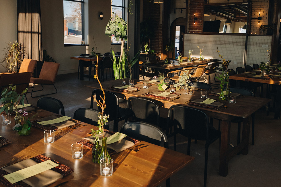 Placesettings with mealcards sit on tables in an urban style venue space.