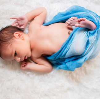 newborn photo with blue wrap on white background