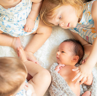 newborn photo with all siblings holding baby