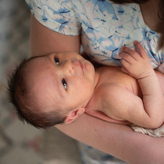 newborn baby looking up at mom with big eyes and natural light