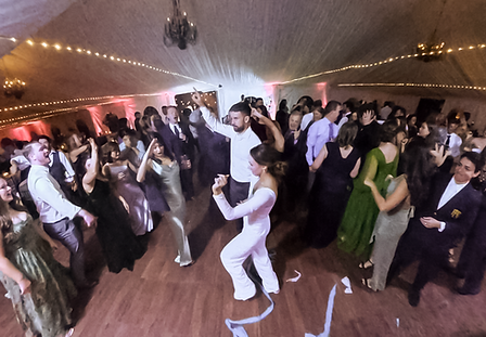 Wedding guests dancing during a packed reception.