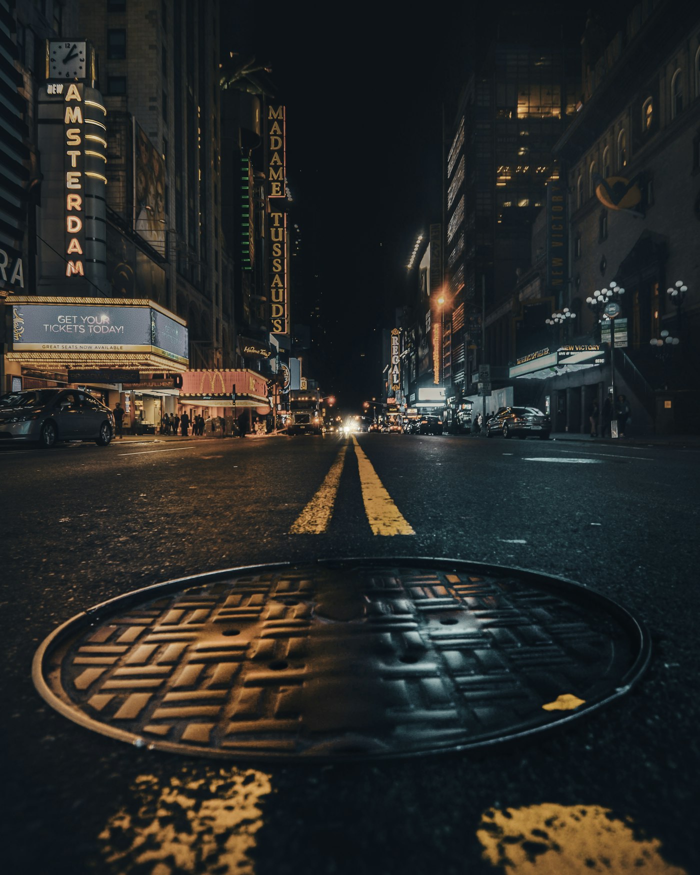 Sewer manhole cover on a New York City street at night