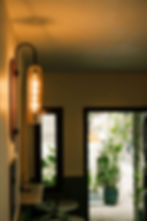 Warmly lit specialty coffee shop interior with wall sconce