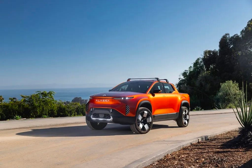 A view of the red Fisker Alaska pickup truck driving on a curved road.