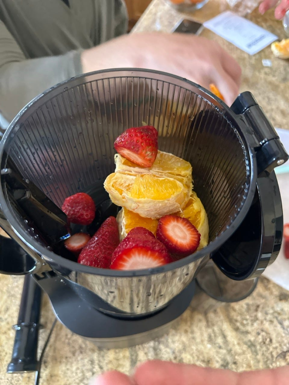 A closer look at the large chute with oranges and strawberrries in the chamber.