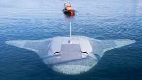 An ominous view of a mostly submerged Manta Ray UUV with a boat in the background