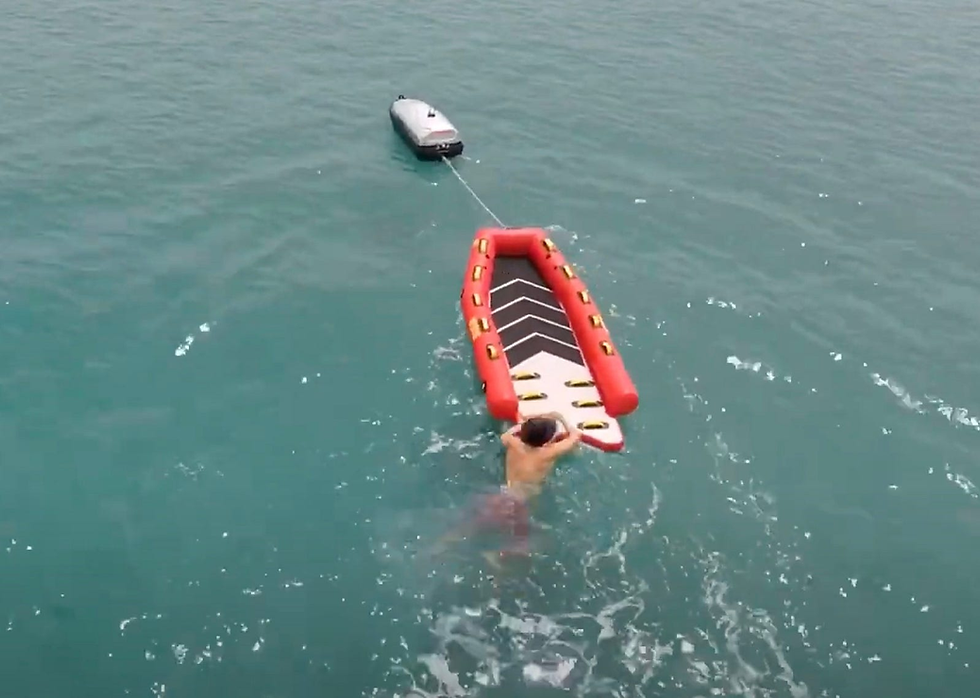 An overhead view of a swimmer being rescued by the eTow watercraft