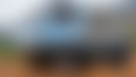 A side-view of an OX Electric truck on a dirt road