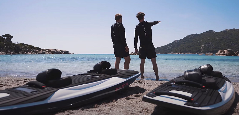 Two surfers in the background of two Awake Ravik electric surfboards front and center. 