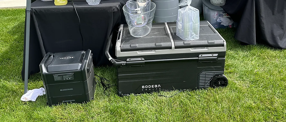 A Bodega 121qt portable cooler being powered by a portable battery generator