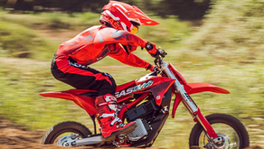 A young rider on their MC-E 5 electric dirt bike in an off-road setting