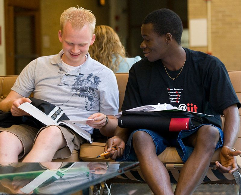 A pair of students conversing about an article. 