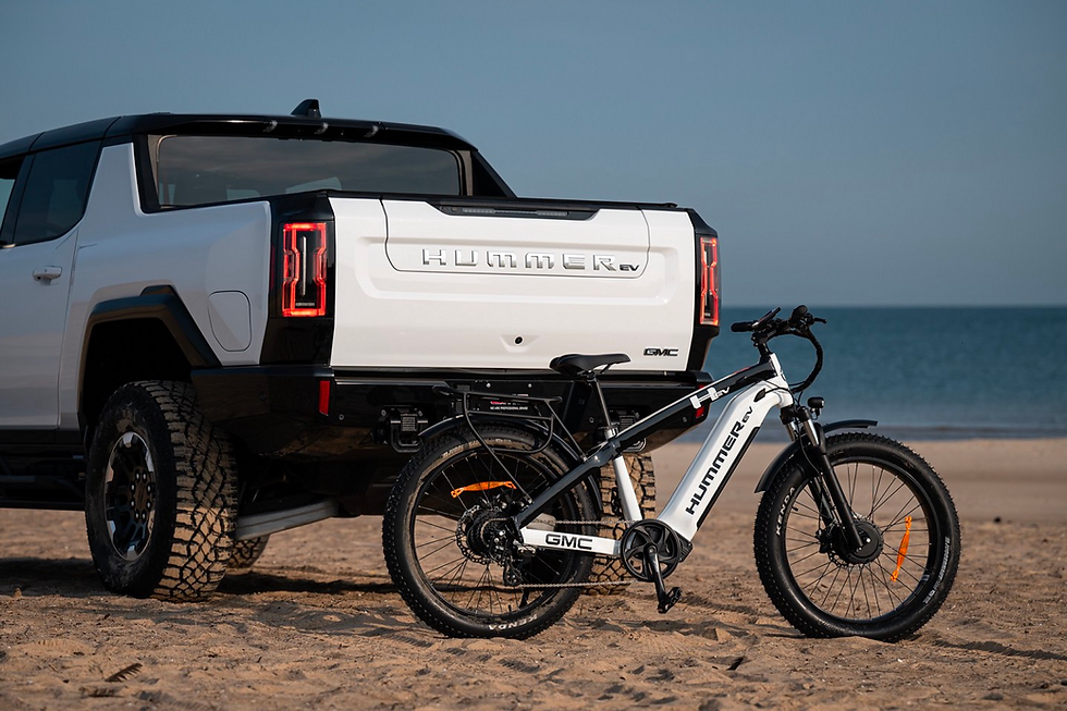 A Hummer EV eBike with a Hummer EV pickup truck in the background.