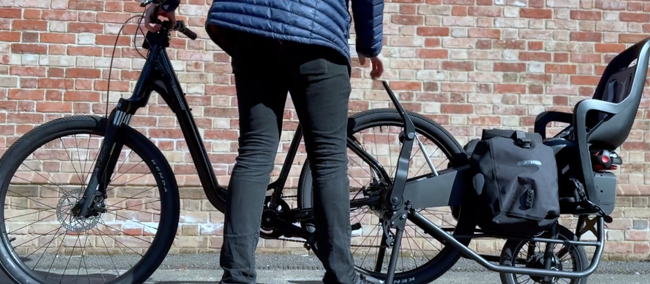 A rider attaching the Convoy C.01 cargo hauler to his existing bike