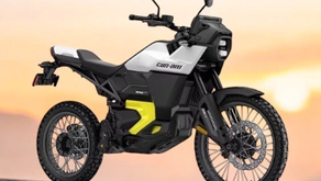 A Can-Am Origin electric motorcycle on full display with a sunset in the background