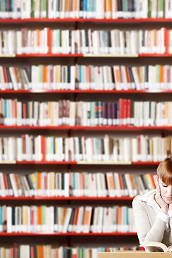 Ragazza che legge in biblioteca