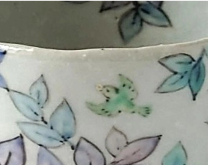 鳥と植物が描かれた陶器のマグカップの接写