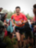 Runner smiling while running through cheering crowd during a race.