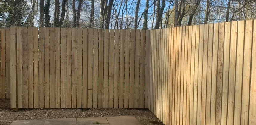 newly installed wooden fence with a portion of cemented ground