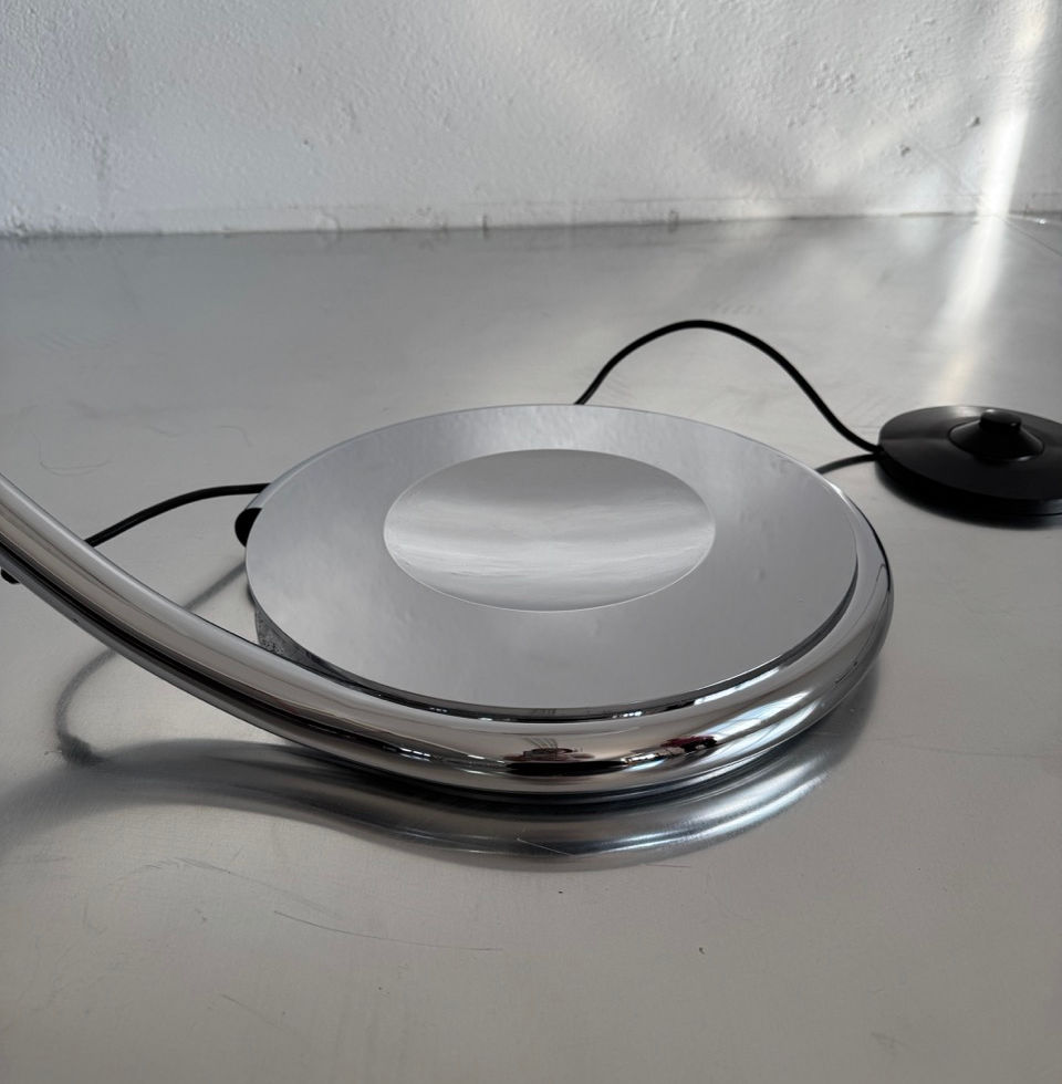 Detailed close-up of the heavy polished chrome circular base and floor switch