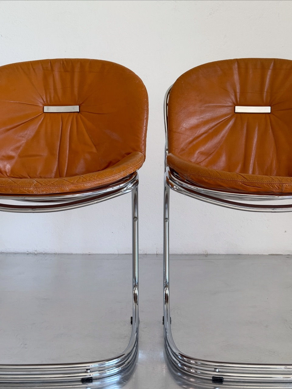 Close-up view of a pair of Gastone Rinaldi Sabrina chairs in cognac leather for RIMA