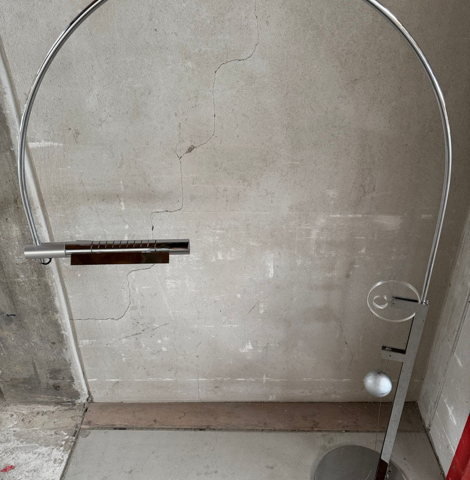 Sleek minimalist chrome floor lamp designed by Baltensweiler in an architectural setting
