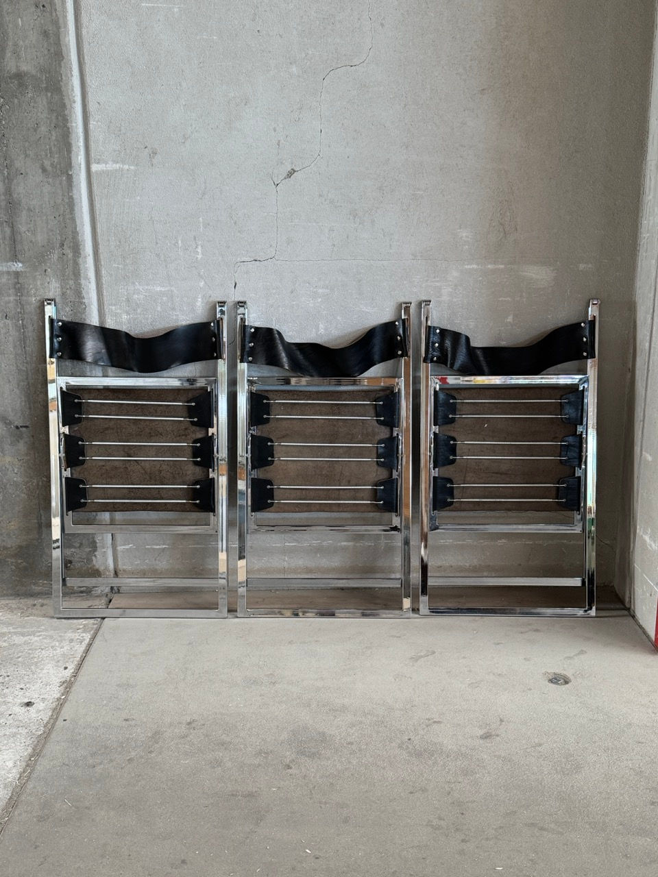 Set of 4 Fontoni and Geraci Elios folding chairs for Luebke folded remarkably flat against a concrete wall