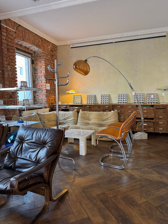 Visitors browsing through mid-century furniture and postmodern floor lamps at the vintage pop-up store event.