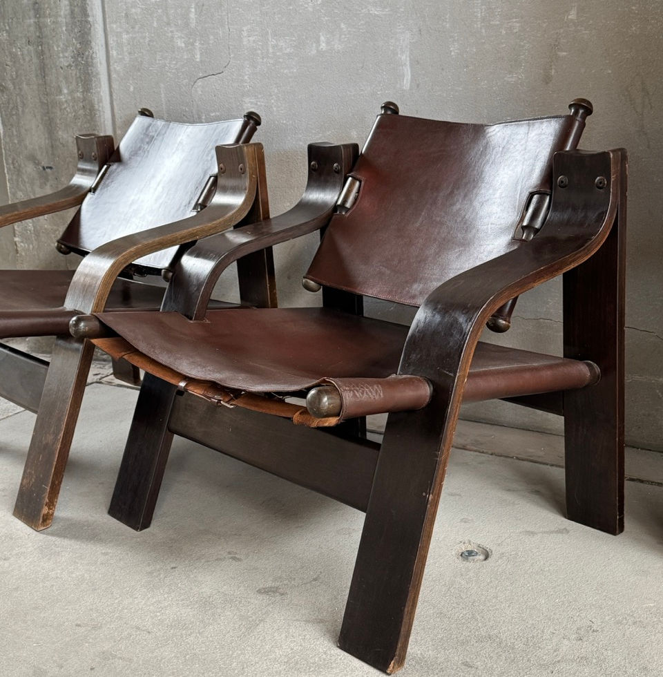 Close-up view of a 1960s Brutalist French safari lounge chair with dark wood and thick leather