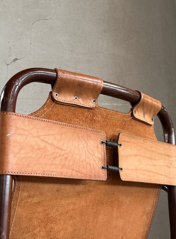 Close-up detail of the suspended saddle leather backrest and bamboo frame of the Tito Agnoli chair