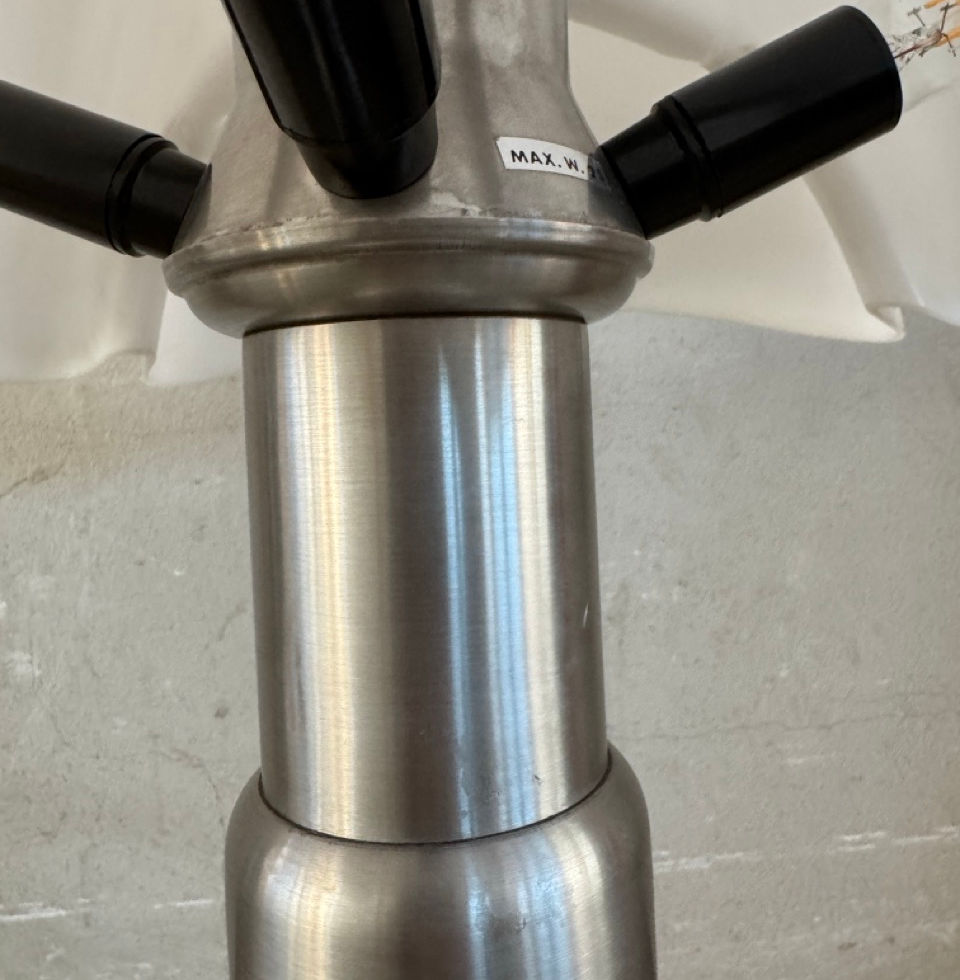 Close-up of the polished metal hardware connecting the stem and opaline diffuser of the Pipistrello lamp